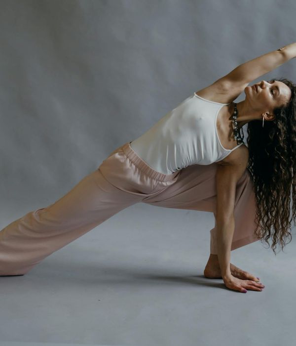 Serene woman in a focused yoga pose in a calm studio.